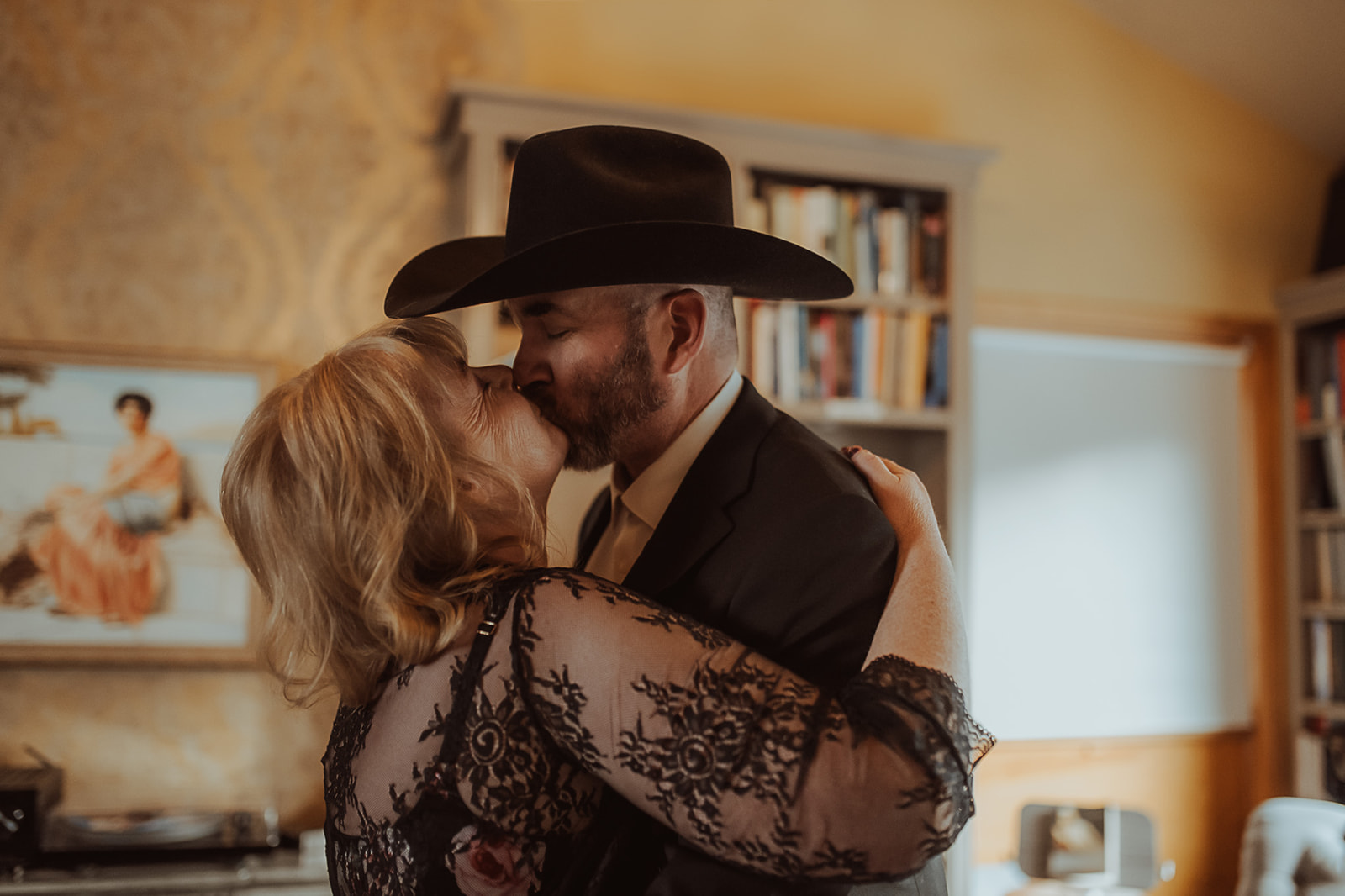 A happy couple kisses in a room full of books after meeting Missoula marriage counselors