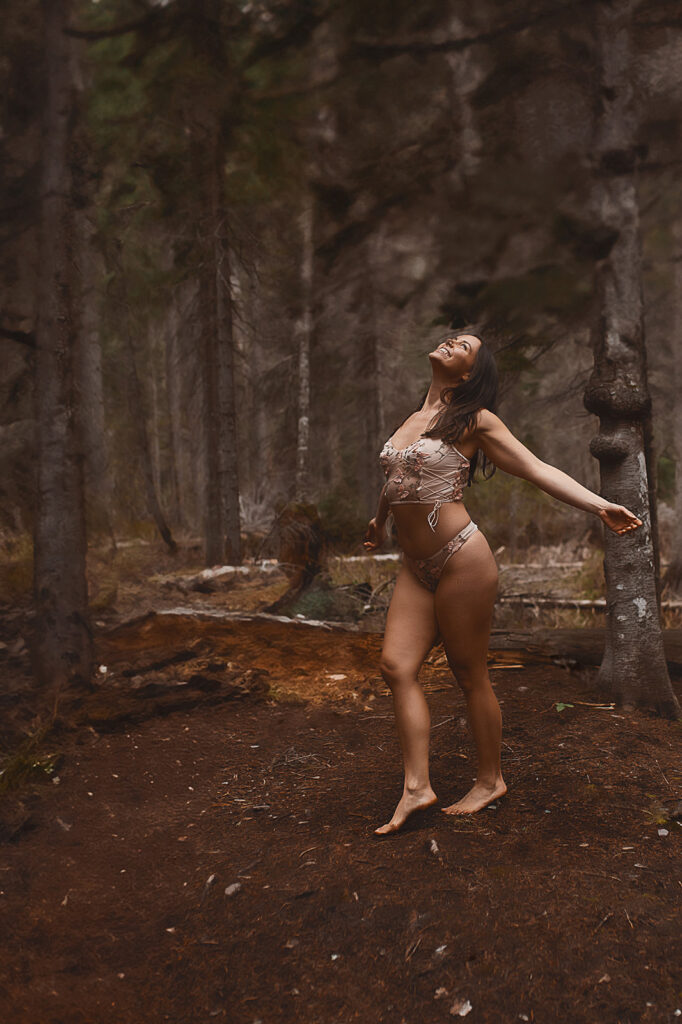 A happy woman dances in a forest in lingerie after visiting Missoula personal trainers