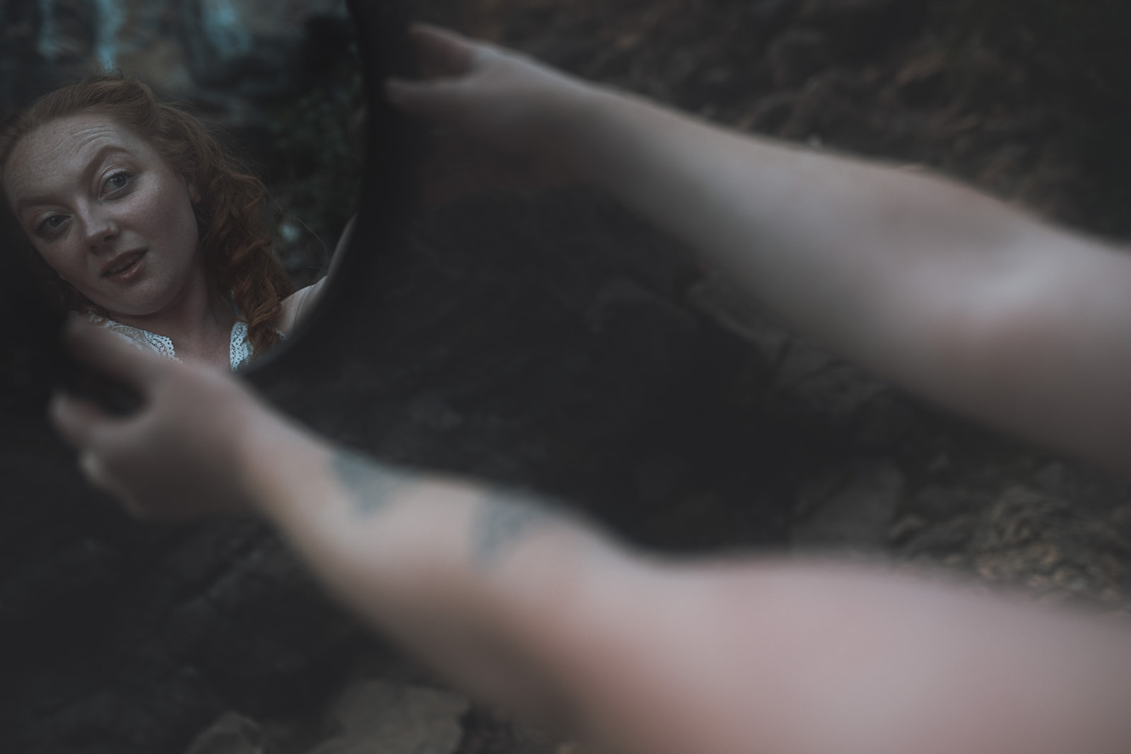 A woman in the forest admires herself in a mirror after visiting hair salons in Corvallis
