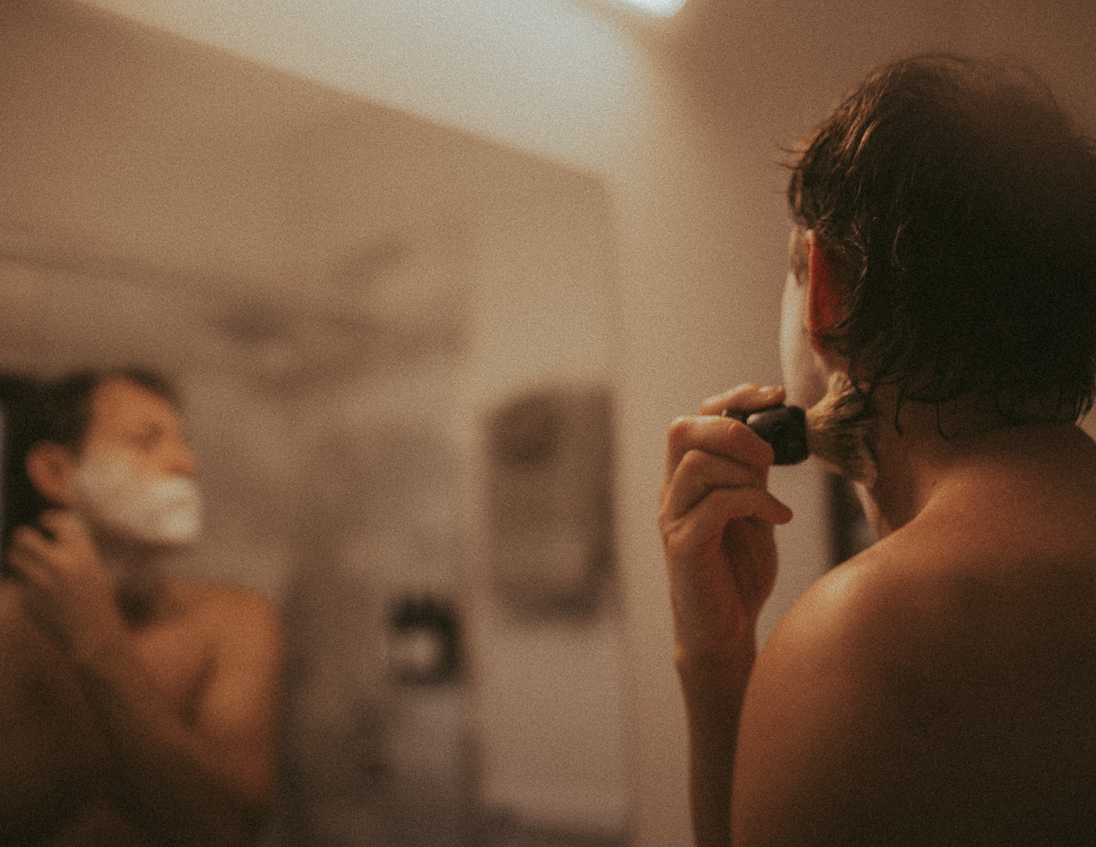a man applies shaving cream in a window at one of the luxury hotels in Montana
