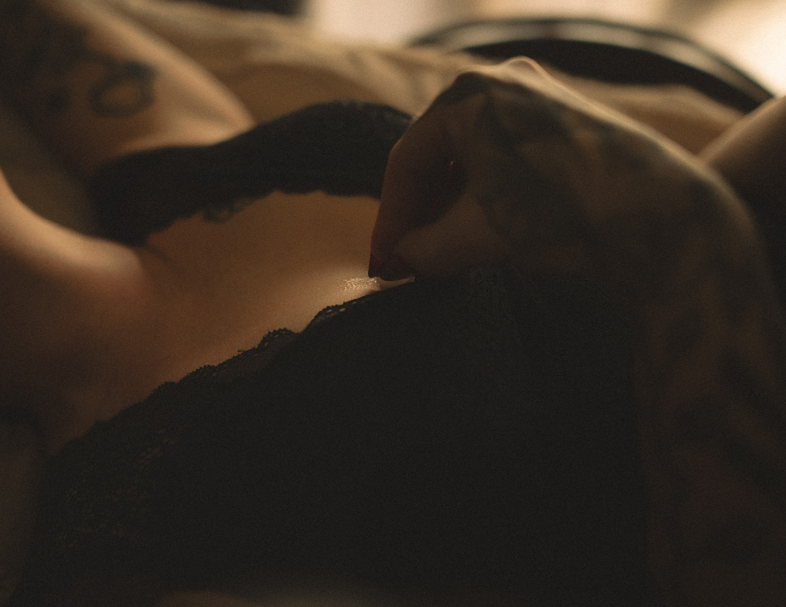 Details of a woman's hand on her black lace lingerie on her chest after finding personal trainer in Kalispell, MT