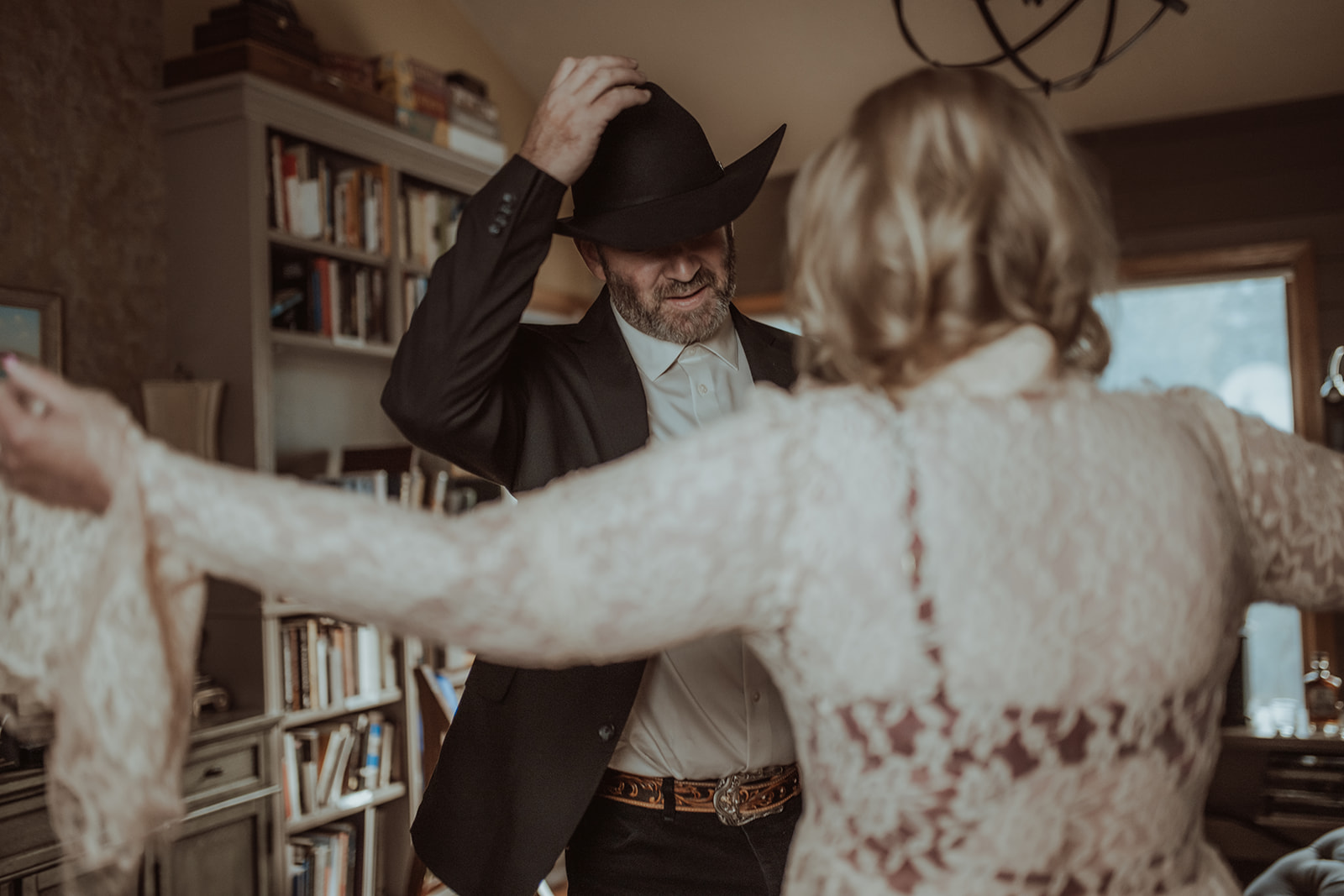 A man removes his hat when seeing his wife in white lace lingerie after visiting beauty salons in Butte, MT