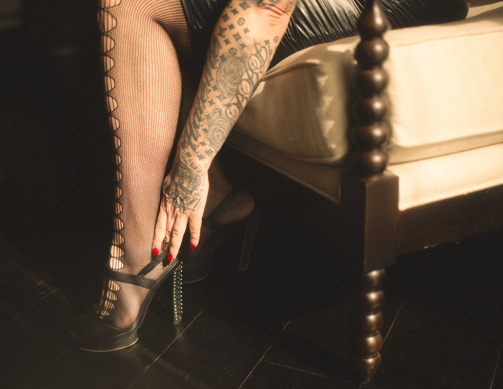 Details of a woman pulling on her high heels in fishnets