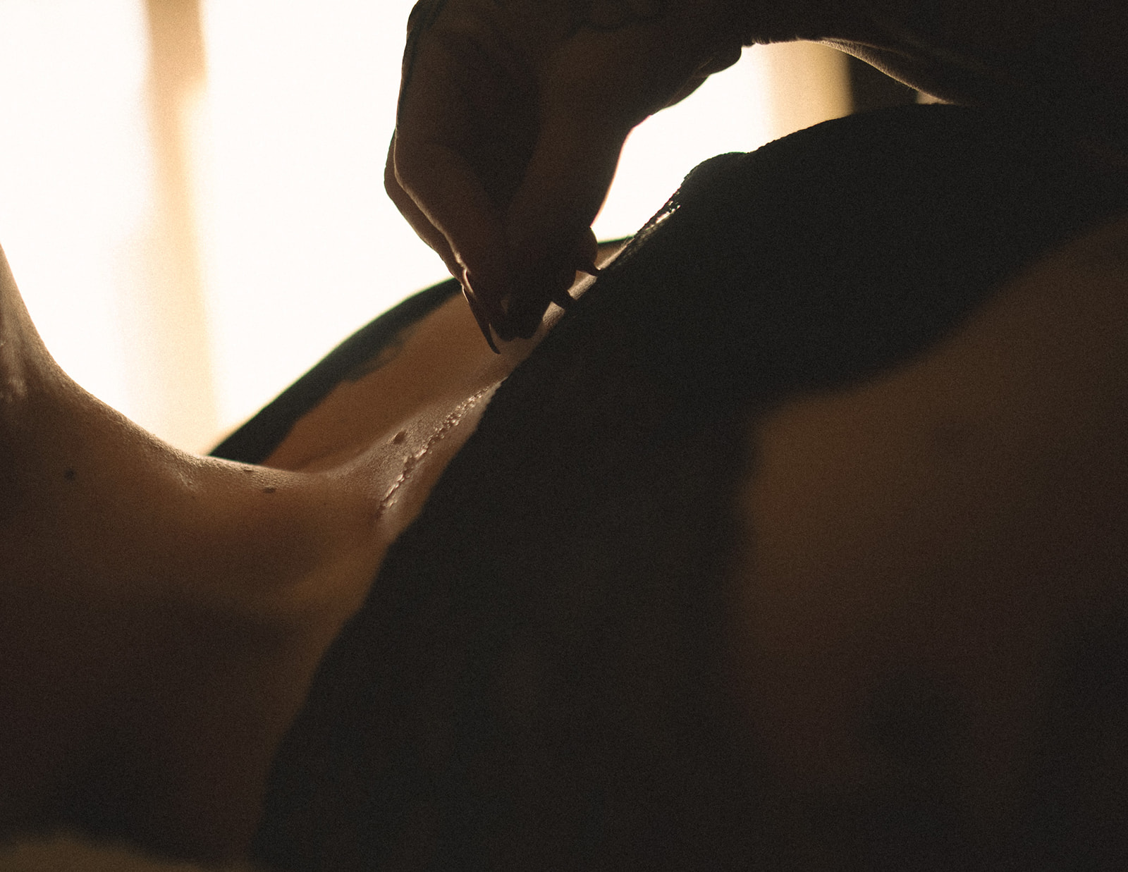 Details of a woman dripping ice on her chest with black nails from visiting nail salons in Bozeman