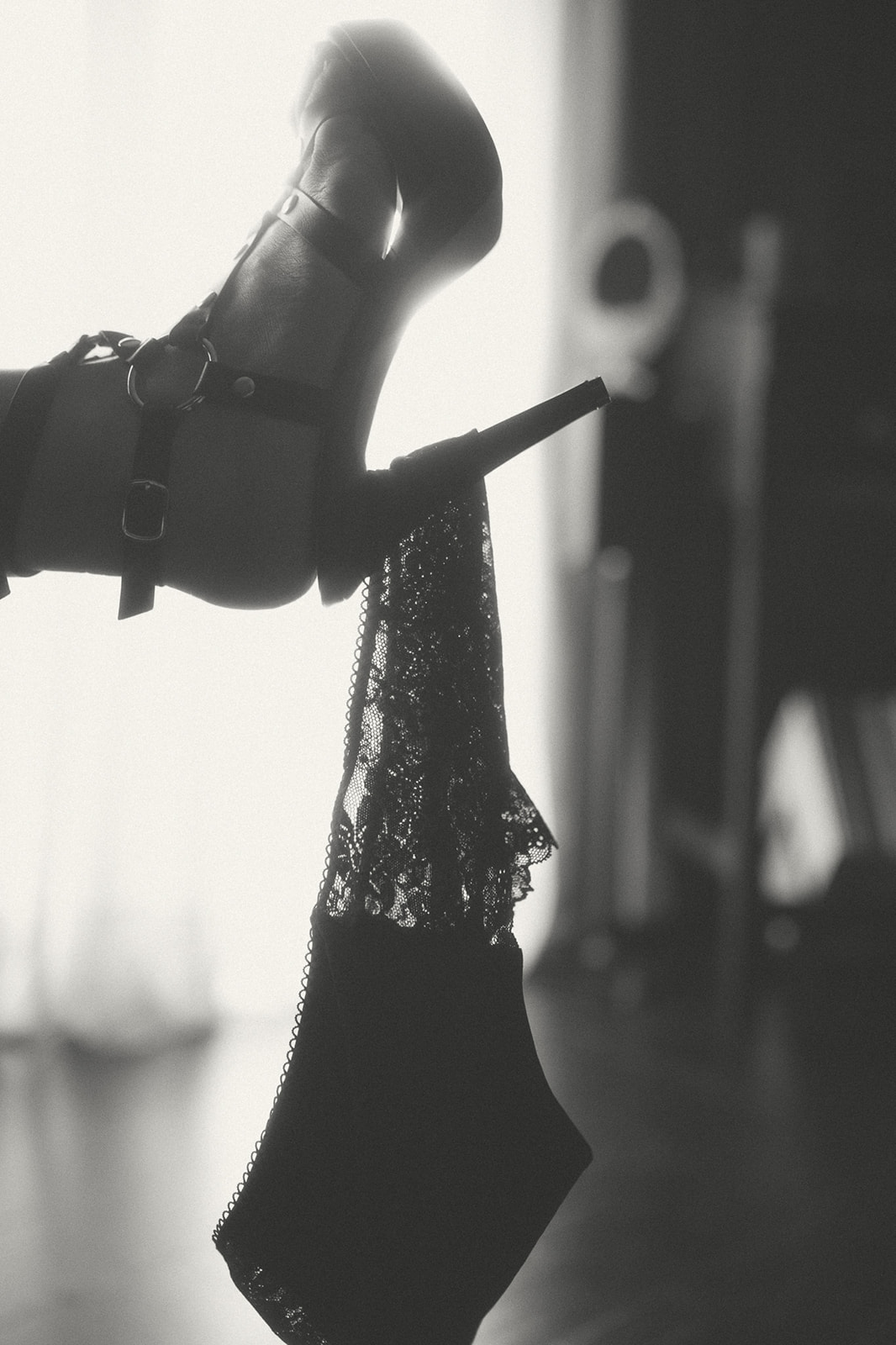 A woman's black lace lingerie hangs from her high heel after visiting The Exotic Peach