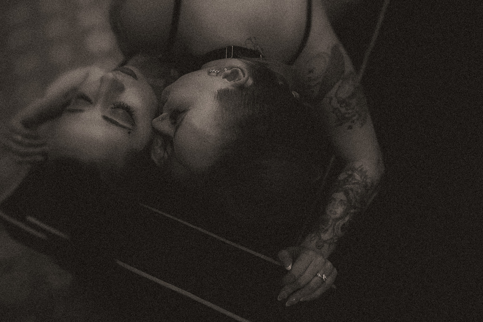 A look down at a couple snuggling on a couch and kissing the cheek of her wife after enjoying date night ideas in Missoula